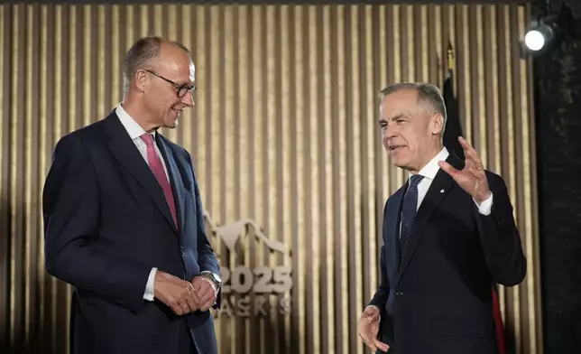 Canadian Prime Minister Mark Carney, right, meets with German Chancellor Friedrich Merz ahead of the G7 Summit at the Pomeroy Kananaskis Mountain Lodge, about 62 miles (100 kilometers) west of Calgary, in Kananaskis, Alberta, Sunday, June 15, 2025. (Adrian Wyld/The Canadian Press via AP)