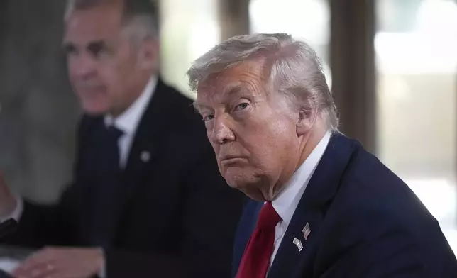 U.S. President Donald Trump, front right, listens to a question being shouted out by a reporter while seated next to Canadian Prime Minister Mark Carney, back left, during working session at the G7 Summit in Kananaskis, Alberta, Canada, Monday, June 16, 2025. (Darryl Dyck/The Canadian Press via AP)