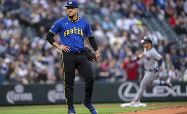 Seattle Mariners starting pitcher Luis Castillo, left, reacts after giving up back-to-back home runs during the third inning of a baseball game against the Cleveland Guardians, Friday, June 13, 2025, in Seattle. (AP Photo/Stephen Brashear)