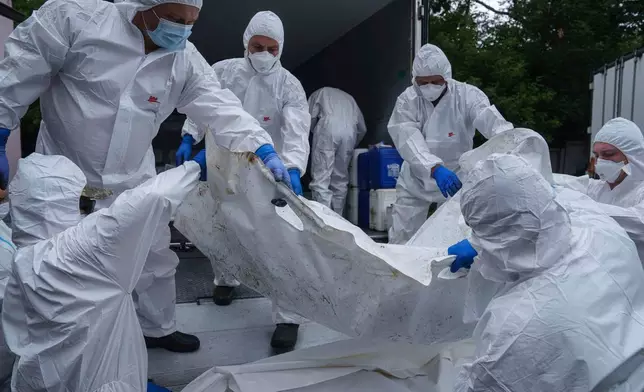Ukrainian servicemen carry a body of their comrade repatriated from Russia, at the morgue in Kyiv, Ukraine, on Thursday, June 26, 2025. (AP Photo/Evgeniy Maloletka)
