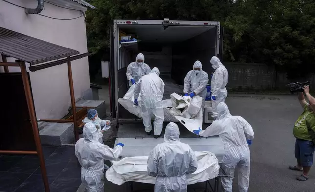 Ukrainian servicemen carry a body of their comrade repatriated from Russia, at the morgue in Kyiv, Ukraine, on Thursday, June 26, 2025. (AP Photo/Evgeniy Maloletka)