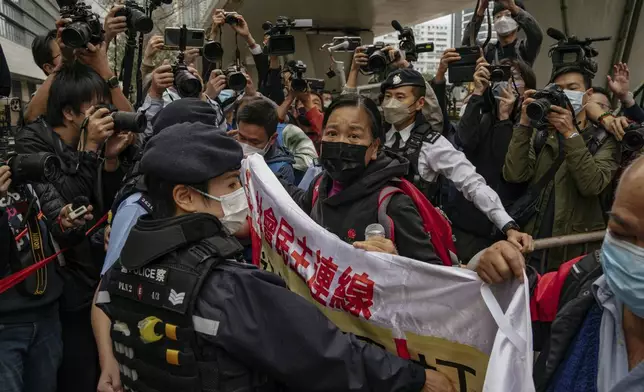 FILE - Photographers take picture of the members of League of Social Democrats scuffling with police outside the West Kowloon Magistrates' Courts ahead of the national security trail for the pro-democracy activists in Hong Kong, on Feb. 6, 2023. (AP Photo/Anthony Kwan, File)