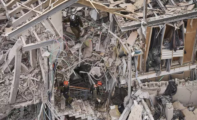 Rescue workers and security forces work at the site of a direct missile strike launched from Iran in Tel Aviv, Israel, on Sunday, June 22, 2025. (AP Photo/Oded Balilty)