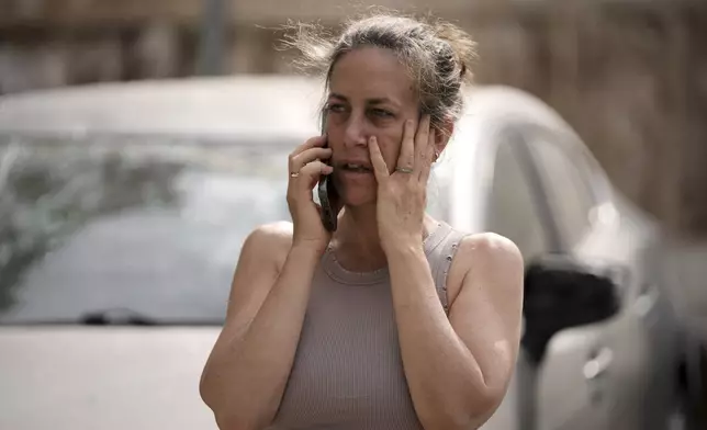 A woman talks on her cellphone at the site where a missile launched from Iran struck in Tel Aviv, Israel, Sunday, June 22, 2025. (AP Photo/Oded Balilty)