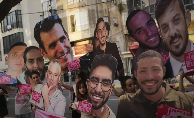 Relatives and supporters of Israeli hostages held by Hamas in Gaza display photos of the captives during a protest demanding their release. in Tel Aviv, Israel, on Saturday, June 21, 2025. (AP Photo/Ohad Zwigenberg)