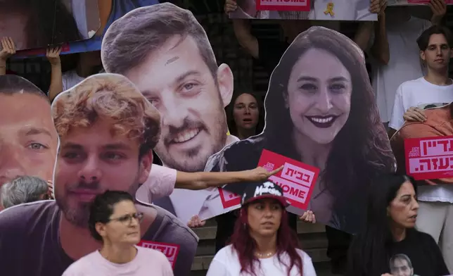 Relatives and supporters of Israeli hostages held by Hamas in Gaza hold photos depicting the faces of Israeli hostages who are being held in the Gaza Strip, during a protest demanding their release from Hamas captivity, in Tel Aviv, Israel, Monday, June 9, 2025. (AP Photo/Ariel Schalit)