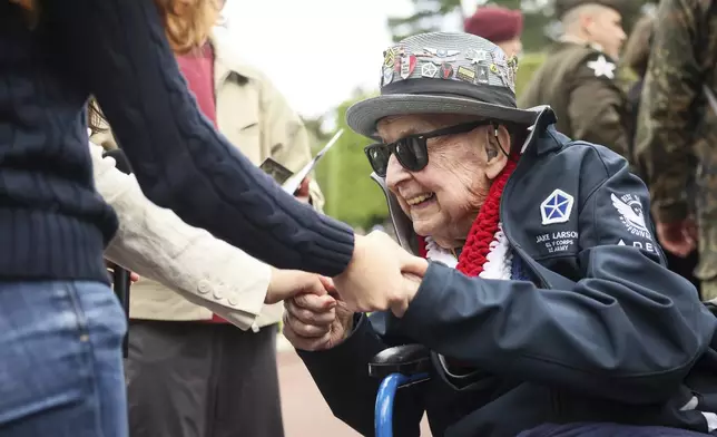 World War II veteran Jake Larson meets youths during ceremonies at the US cemetery to commemorate the 81st anniversary of the D-Day landings, Friday, June 6, 2025 in Colleville-sur-Mer, Normandy. (AP Photo/Thomas Padilla)
