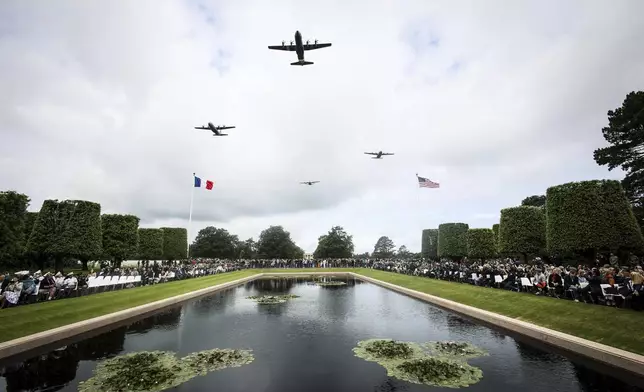 War planes fly over the US cemetery during a ceremony to commemorate the 81st anniversary of the D-Day landings, Friday, June 6, 2025 in Colleville-sur-Mer, Normandy. (AP Photo/Thomas Padilla)