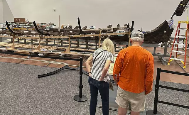 Visitors to the New York State Museum view a Revolutionary War-era gunboat that is being partially reconstructed, Friday, May 30, 2025, in Albany, New York. (AP Photo/Michael Hill)