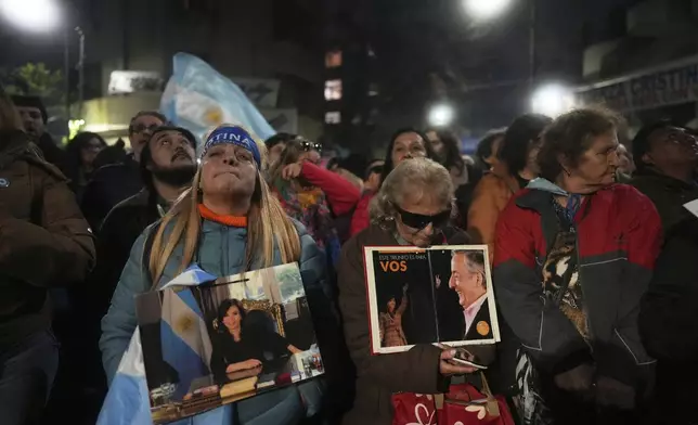 Supporters of former President Cristina Fernandez gather outside her home after a federal court granted her request to serve a six-year prison sentence for corruption at her home, in Buenos Aires, Argentina, Tuesday, June 17, 2025. (AP Photo/Natacha Pisarenko)