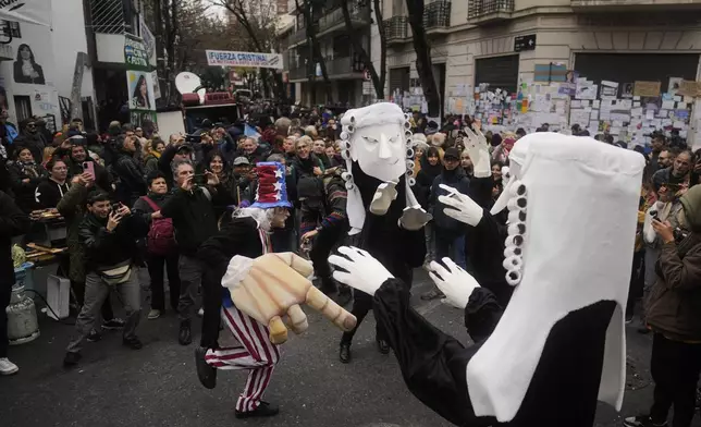 Supporters of Argentina's former President Cristina Fernandez gather outside her home one week after the nation's Supreme Court upheld her corruption conviction in Buenos Aires, Argentina, Tuesday, June 17, 2025. (AP Photo/Natacha Pisarenko)