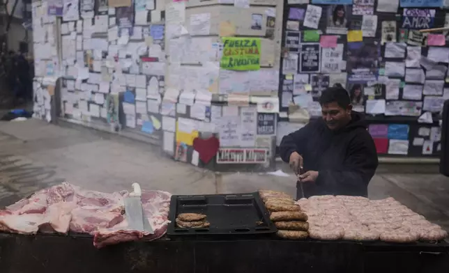 A street vendor cooks barbecue outside the home of Argentina's former President Cristina Fernandez after the nation's Supreme Court upheld her corruption conviction in Buenos Aires, Argentina, Tuesday, June 17, 2025. (AP Photo/Natacha Pisarenko)
