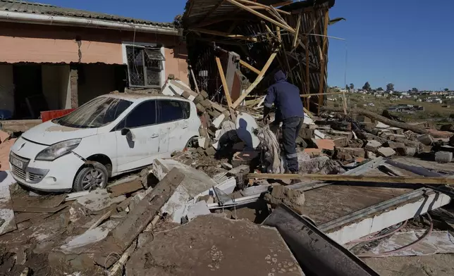 A resident looks through the remnants after floods swept through the area in Mthatha, South Africa, Thursday, June 12, 2025. (AP Photo/Themba Hadebe)