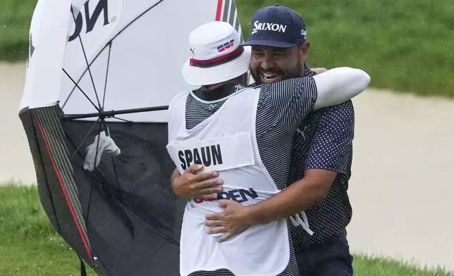 J.J. Spaun celebrates by hugging his caddie, Mark Carens, after making a birdie putt on the 18th hole during the final round of the U.S. Open golf tournament at Oakmont Country Club Sunday, June 15, 2025, in Oakmont, Pa. (AP Photo/Gene J. Puskar)