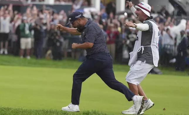 J.J. Spaun celebrates with his caddie, Mark Carens, after making a birdie putt on the 18th hole during the final round of the U.S. Open golf tournament at Oakmont Country Club Sunday, June 15, 2025, in Oakmont, Pa. (AP Photo/Seth Wenig)