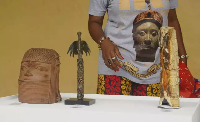 Benin bronzes looted in the past and returned to Nigeria are examined during a handing over ceremony in Lagos, Nigeria, Saturday, June 21, 2025. (AP Photo/Sunday Alamba)