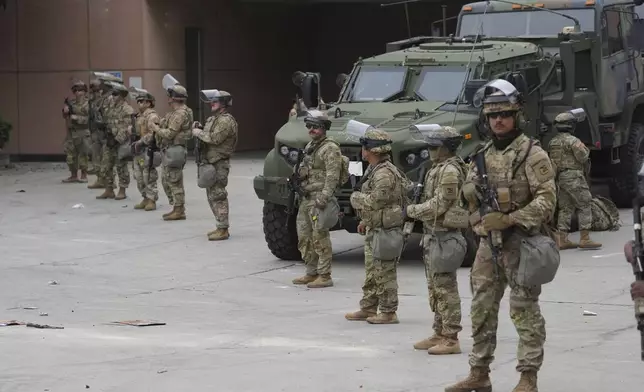 U.S. National Guard are deployed outside the federal prison in downtown Los Angeles, Sunday, June 8, 2025, following a immigration raid protest the night before. (AP Photo/Jae Hong)