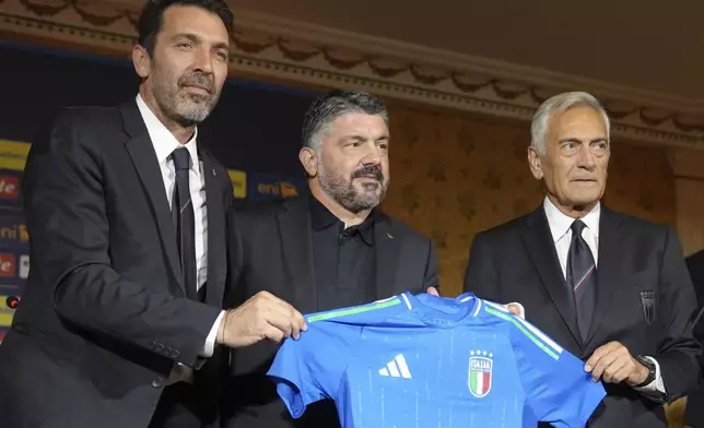 Newly appointed Italian national soccer team head coach Rino Gattuso, center, poses for photographers with Italian Soccer Federation, FGCI, president Gabriel Gravina, right, and former player Gianluigi Buffon as he arrives for a press conference, in Rome, Thursday, June 19, 2025. (AP Photo/Alessandra Tarantino)