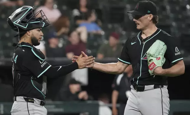 Arizona Diamondbacks catcher Jose Herrera, left, celebrates with relief pitcher Shelby Miller after the Diamondbacks defeated the Chicago White Sox in a baseball game in Chicago, Tuesday, June 24, 2025. (AP Photo/Nam Y. Huh)