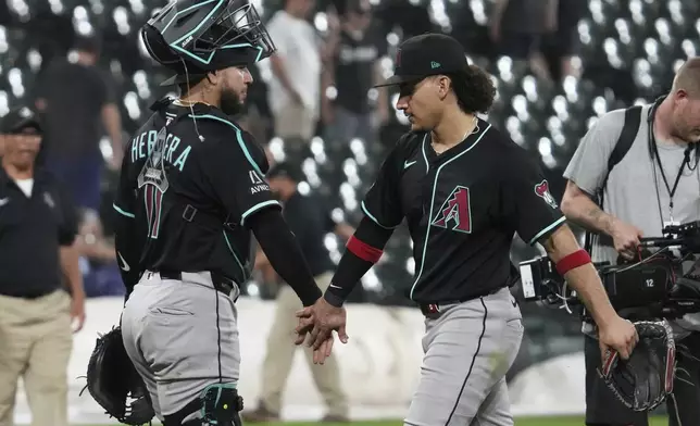 Arizona Diamondbacks catcher Jose Herrera, left, celebrates with center fielder Alek Thomas after the Diamondbacks defeated the Chicago White Sox in a baseball game in Chicago, Tuesday, June 24, 2025. (AP Photo/Nam Y. Huh)