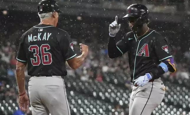 Arizona Diamondbacks' Geraldo Perdomo, right, celebrates with first base coach Dave McKay after hitting a one-run single during the seventh inning of a baseball game against the Chicago White Sox in Chicago, Tuesday, June 24, 2025. (AP Photo/Nam Y. Huh)