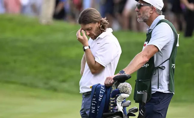 Tommy Fleetwood, from England, reacts as Keegan Bradley prepares to putt for the win during the final round of the Travelers Championship golf tournament at TPC River Highlands, Sunday, June 22, 2025, in Cromwell, Conn. At right is Fleetwood's caddie Ian Finnis. (AP Photo/Jessica Hill)