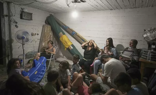 Israelis take shelter during air raid sirens warning of incoming strikes by Iran, in Bnei Brak, near Tel Aviv, Israel, Tuesday, June 17, 2025. (AP Photo/Oded Balilty)