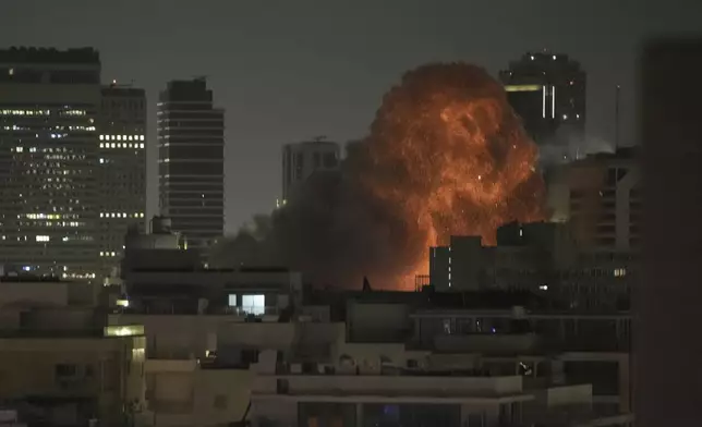 An explosion is seen during a missile attack in Tel Aviv, Israel, Sunday, June 15, 2025. (AP Photo/Leo Correa)