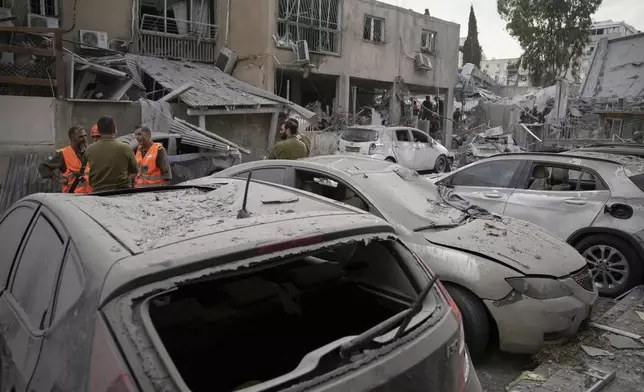 Damaged cars are seen at the site where an Iranian missile struck in Bnei Brak, near Tel Aviv, Israel, Monday, June 16, 2025. (AP Photo/Leo Correa)