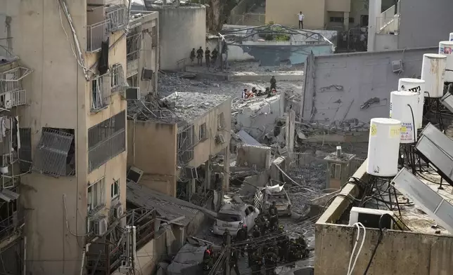 Rescue workers, police and military inspect the site where an Iranian missile struck in Bnei Brak, near Tel Aviv, Israel, Monday, June 16, 2025. (AP Photo/Leo Correa)