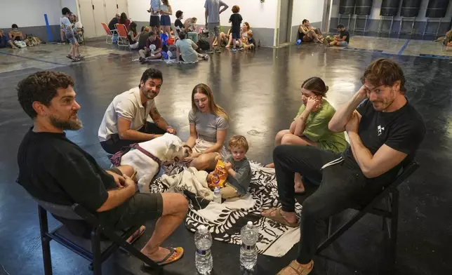 Israelis take shelter in a parking garage during a missile alert from Iran, in Tel Aviv, Israel, Sunday, June 15, 2025. (AP Photo/Baz Ratner)"