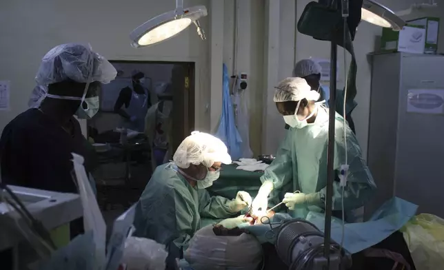 International Committee of the Red Cross doctors (ICRC), operates on a man wounded by an airstrike at a field hospital in Akobo, South Sudan, Friday, May 23, 2025. (AP Photo/Joseph Falzetta)
