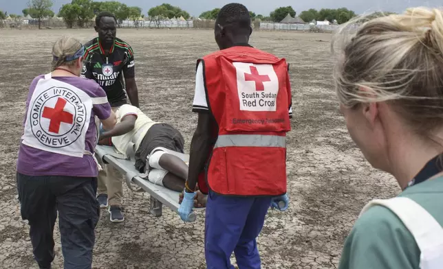 Medical staff with the International Committee of the Red Cross (ICRC) and South Sudan Red Cross carry a weapon-wounded patient in Akobo, South Sudan, Saturday, May 24, 2025. (AP Photo/Joseph Falzetta)