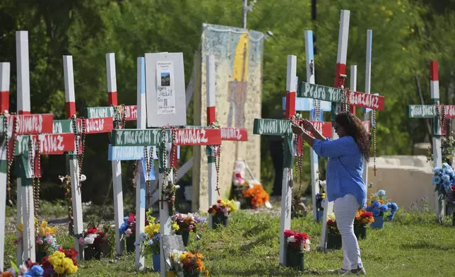 Angelita Olvera visits a memorial honoring the victims and survivors of a human smuggling tragedy where dozens of migrants were found in an airless tractor-trailer rig two years ago, in San Antonio, Friday, June 27, 2025. (AP Photo/Eric Gay)