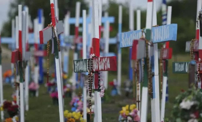 Crosses stand at a memorial honoring the victims and survivors of a human smuggling tragedy where dozens of migrants were found in an airless tractor-trailer rig two years ago, in San Antonio, Friday, June 27, 2025. (AP Photo/Eric Gay)