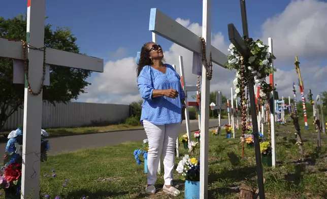 Angelita Olvera visits a memorial honoring the victims and survivors of a human smuggling tragedy where dozens of migrants were found in an airless tractor-trailer rig in 2022, in San Antonio, Friday, June 27, 2025. (AP Photo/Eric Gay)