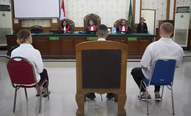 British nationals, from left, Lisa Stocker, Jonathan Collyer, and Phineas Float who are accused of smuggling nearly a kilogram (over two pounds) of cocaine into Indonesia sit on the defendant's chairs during their trial hearing at Denpasar District Court in Denpasar, Bali, on Tuesday, June 3, 2025. (AP Photo/Firdia Lisnawati)