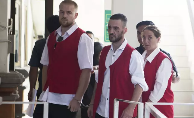 British nationals, from left, Phineas Float, Jonathan Collyer, and Lisa Stocker who are accused of smuggling nearly a kilogram (over two pounds) of cocaine into Indonesia are escorted by security officers before the start of their trial hearing at Denpasar District Court in Denpasar, Bali, on Tuesday, June 3, 2025. (AP Photo/Firdia Lisnawati)