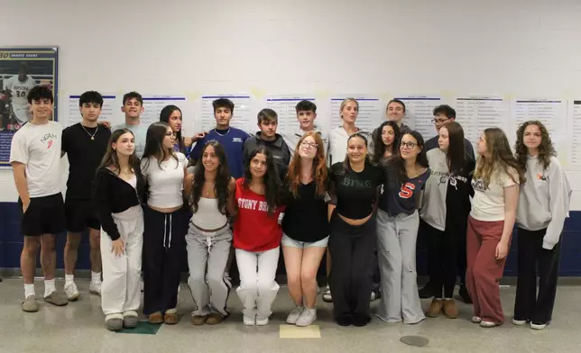 Twin students pose for a group photo during rehearsal for Plainview-Old Bethpage John F. Kennedy High School's graduation ceremony at Hofstra University in Hempstead, N.Y., on Tuesday, June 17, 2025. (AP Photo/Philip Marcelo)