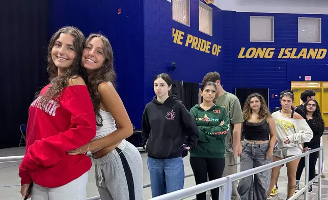 Twin sisters Arianna Cammareri, left, and Julianna Cammareri attend rehearsal for Plainview-Old Bethpage John F. Kennedy High School's graduation ceremony at Hofstra University in Hempstead, N.Y., on Tuesday, June 17, 2025. (AP Photo/Philip Marcelo)