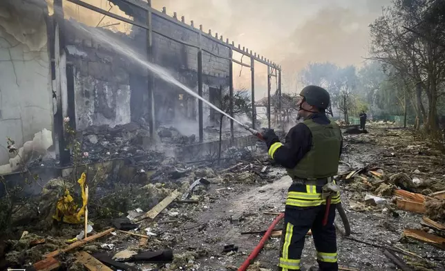 In this photo provided by the Ukrainian Emergency Service, a firefighter tackles a blaze after a Russian attack that hit a private house in Odesa region, Ukraine, Wednesday, June 11, 2025. (Ukrainian Emergency Service via AP)
