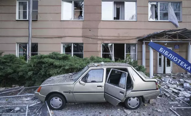A car is seen damaged in front of a residential multi-storey building damaged after a Russian drone strike on Kyiv, Ukraine, on Friday, June 6, 2025. (AP Photo/Evgeniy Maloletka)