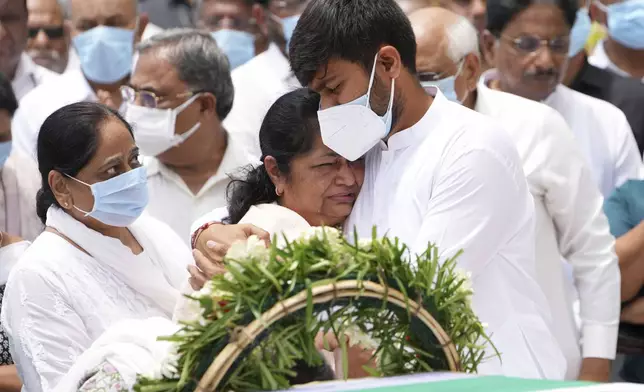 Rushabh Rupani, son of former Chief Minister of Gujarat Vijay Rupani, consoles his mother Anjali Rupani as they receive the body of Vijay Rupani, who died in Thursday's Air India plane crash, in Ahmedabad, India, Monday, June 16, 2025. (AP Photo/Ajit Solanki)