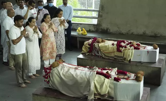 Family members of Dilip Patel and Meena Patel, both victims of the Air India plane crash, pays last respect to their parent during the cremation at a crematorium in Ahmedabad, India, Monday, June 16, 2025. (AP Photo/Ajit Solanki)