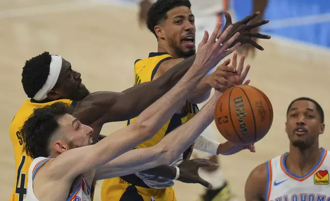 Indiana Pacers forward Pascal Siakam, Oklahoma City Thunder forward Chet Holmgren, left, and Indiana Pacers guard Tyrese Haliburton, center, battle for the rebound during the second half of Game 5 of the NBA Finals basketball series, Monday, June 16, 2025, in Oklahoma City. (AP Photo/Nate Billings)