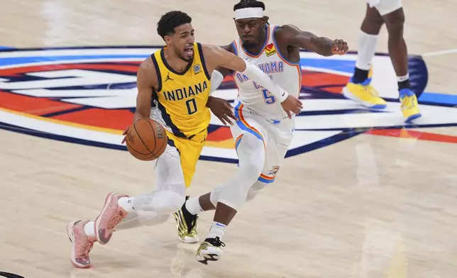 Indiana Pacers guard Tyrese Haliburton (0) drives past Oklahoma City Thunder guard Luguentz Dort (5) during the second half of Game 5 of the NBA Finals basketball series, Monday, June 16, 2025, in Oklahoma City. (AP Photo/Kyle Phillips)