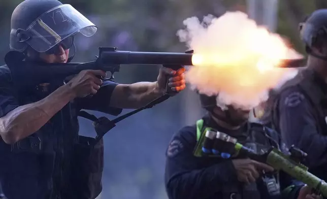 A police officer fires a soft round near the metropolitan detention center of downtown Los Angeles, Sunday, June 8, 2025, following last night's immigration raid protest. (AP Photo/Eric Thayer)
