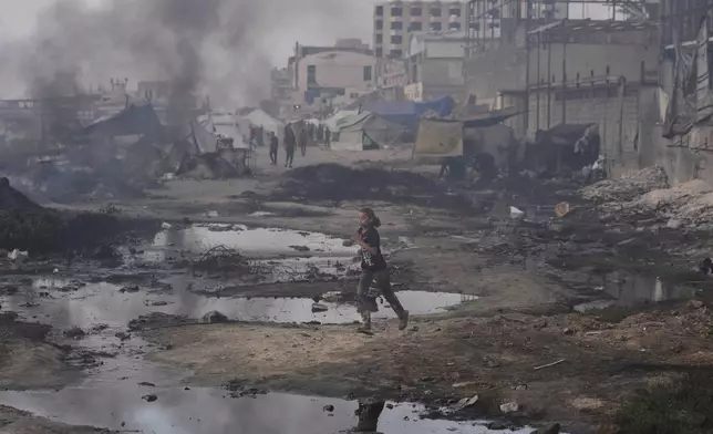 A Palestinian girl runs past the ruins of destroyed buildings along the Gaza City shoreline on Monday, June 9, 2025. (AP Photo/Jehad Alshrafi)