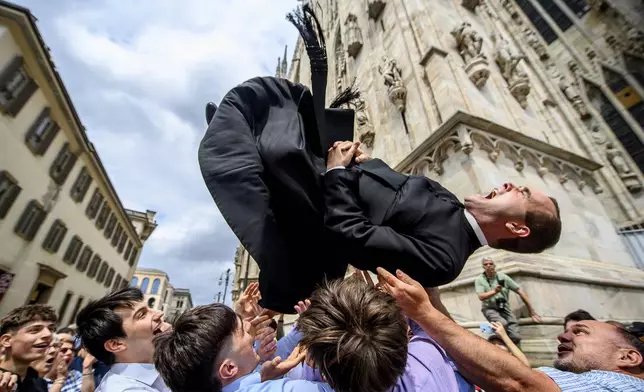 A newly-ordained priest is thrown in the air during celebrations after the service in the Duomo gothic cathedral for the ordination of 11 new priests of the Ambrosian Church, in Milan, Italy, Saturday, June 7, 2025 (Claudio Furlan/LaPresse via AP)