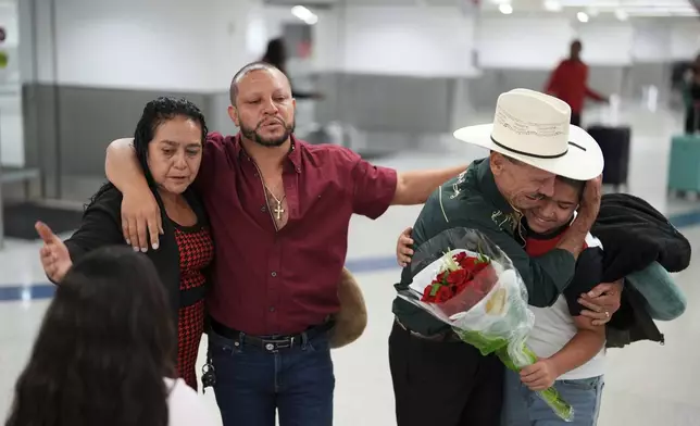 Alfredo de Jesus Reynoso Gonzalez, 73, second right, and wife Vicenta Aguilar, left, greet their son, center, they are seeing for the first time in 22 years, and two grandchildren they were meeting in person for the first time, as they arrive from Guatemala for a visit, at Miami International Airport, Monday, June 9, 2025, in Miami. (AP Photo/Rebecca Blackwell)